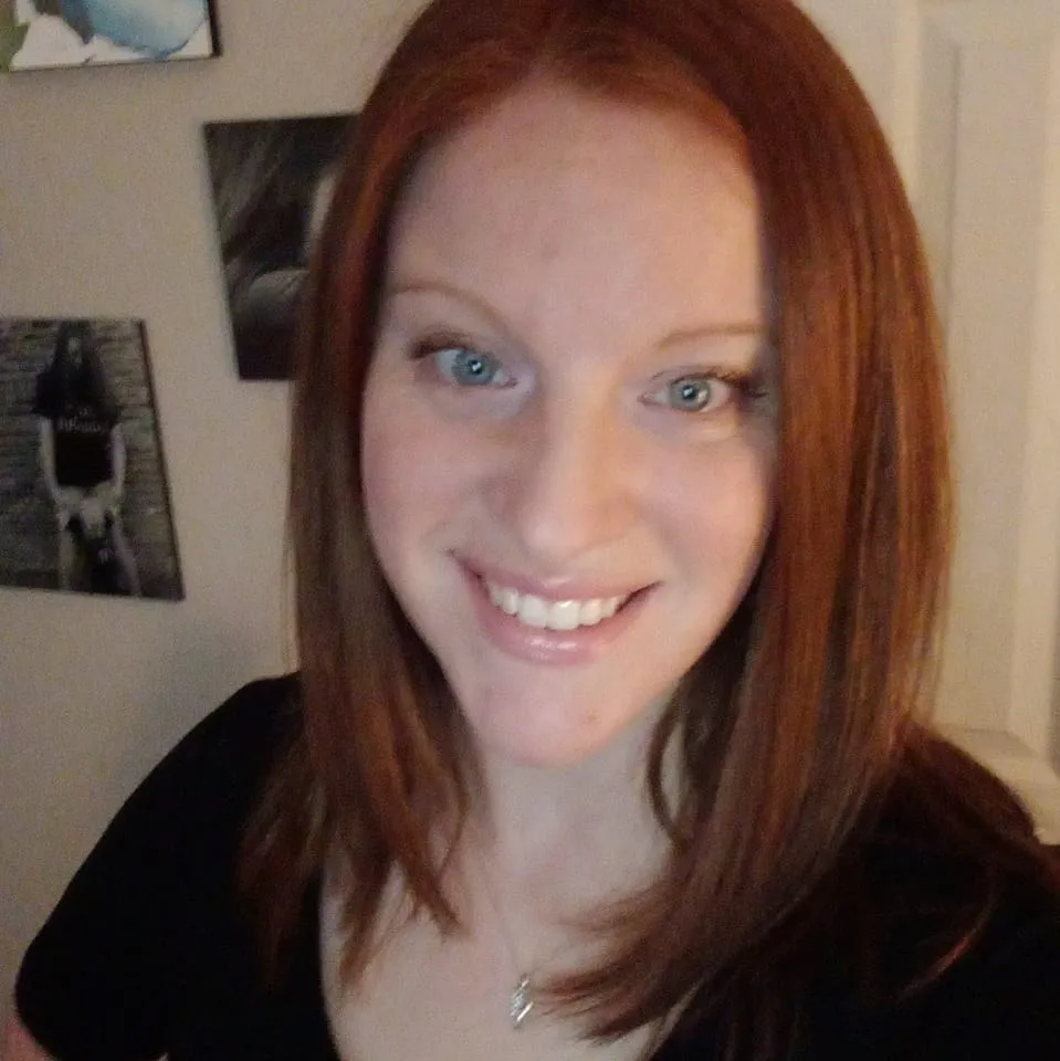 Carol Poynter smiling in a warmly lit room with wall art in the background. A satisfied customer of McMahan Rolloffs in Greenfield, Indiana, sharing her great experience with reliable dumpster rental and waste removal services