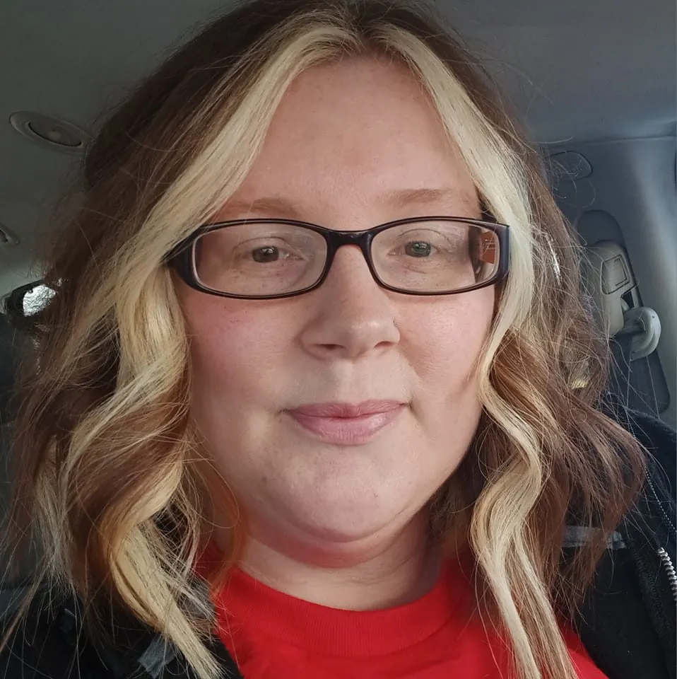 Jaime Lynn Covert smiling inside a vehicle, showcasing her blonde and brown wavy hair. A satisfied customer of McMahan Rolloffs in Greenfield, Indiana, sharing her great experience with reliable dumpster rental and waste removal services.