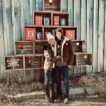 McCready Eric posing with a loved one in front of a festive wooden crate display. A happy customer of McMahan Rolloffs in Greenfield, Indiana, sharing their experience with professional dumpster rental and waste removal services.